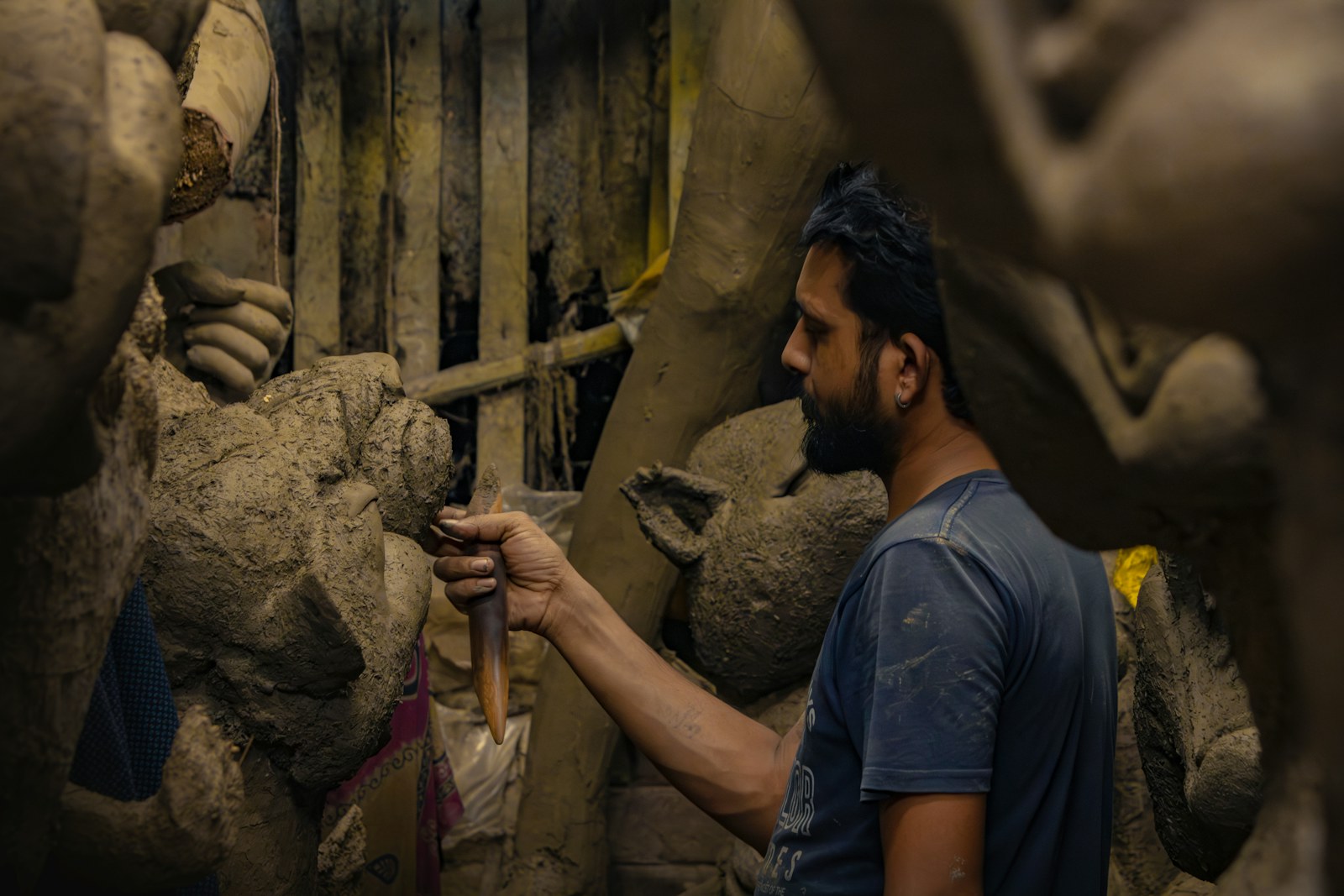 Sculptor forming a detailed clay figure in a workshop